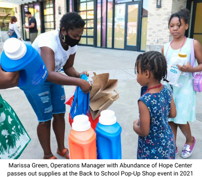 Marissa Green, Operations Manager with Abundance of Hope Center passing out supplies at the Back to School Pop-Up Shop event in 2021