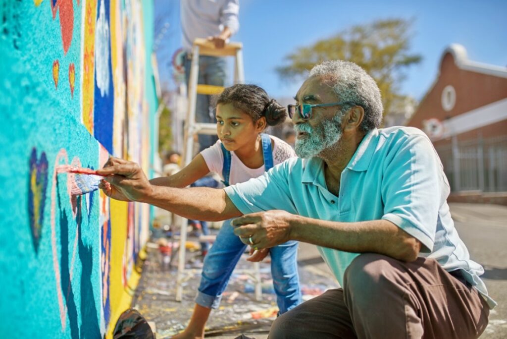 Man and child painting mural