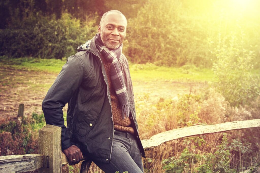 man leaning on fence